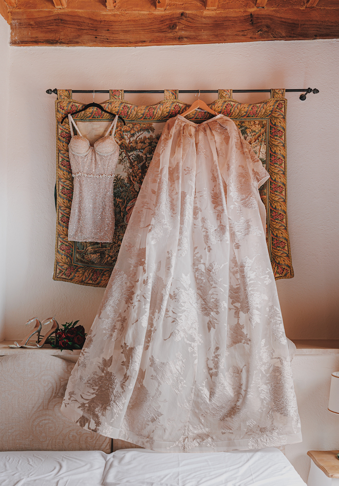 The bride's mini dress and skirt hanging.