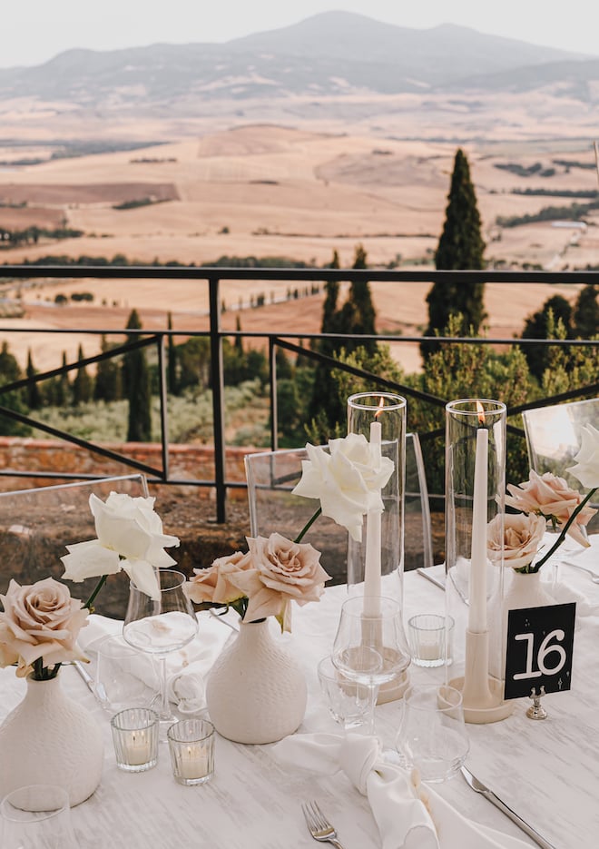 Blush and white roses decorating the reception table overlooking the Tuscan countryside.