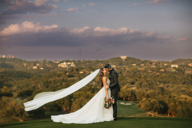 The bride and groom kissing in the Austin hill country.