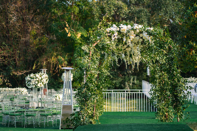 Verdant Greenery and White Florals adorn this backyard garden ceremony.