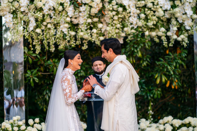 The bride and groom holding hands and laughing at their ceremony.