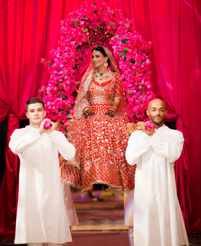 Aziza being carried with pink florals above her.