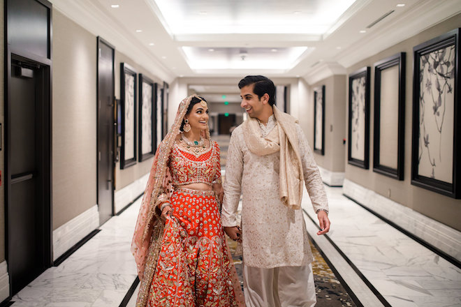 The bride and groom walking through The Post Oak Hotel before their Mehndi.