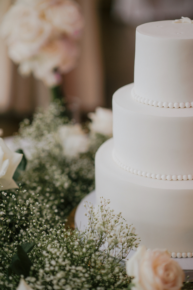 Three-tiered white wedding cake at a sophisticated affair at the Petroleum Club of Houston.