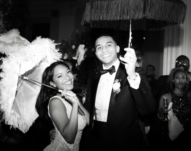 The bride and groom holding umbrellas at their luxurious Houston wedding reception.