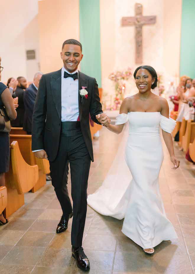 The bride and groom holding hands and walking back down the aisle. 