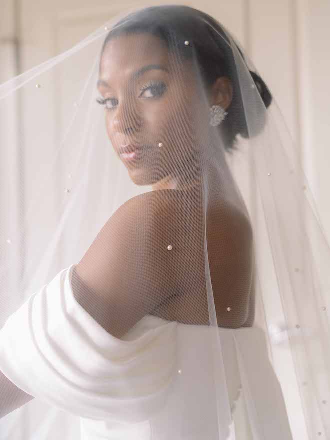 The bride looking through her pearl veil.