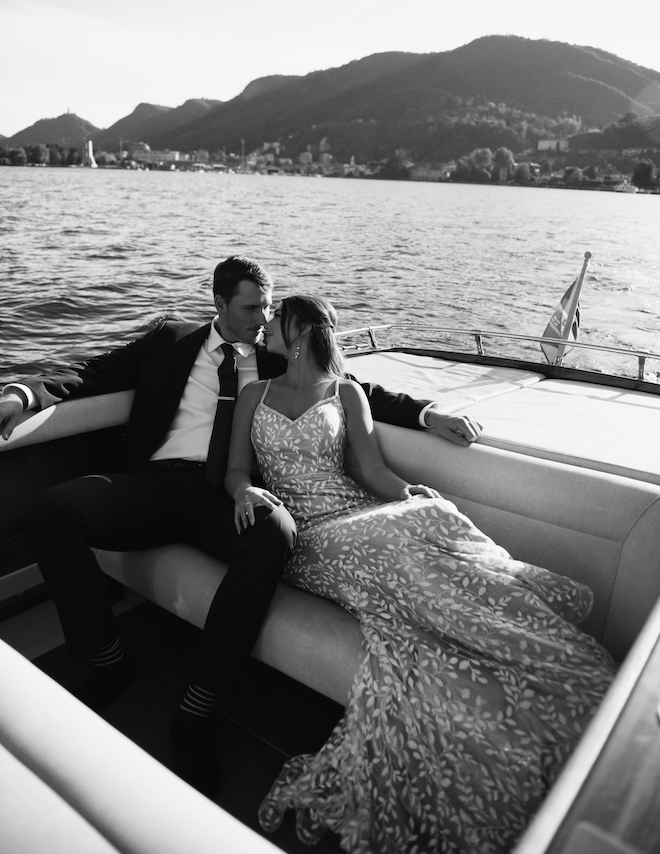 The bride and groom about to kiss as they sit in the back of a boat on their waterfront elopement.