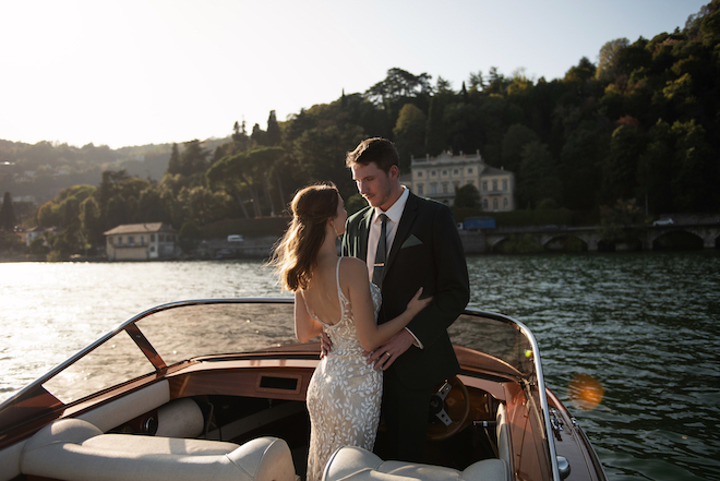 The bride and groom gazing at each other on a boat in Lake Como, Italy.