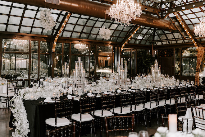 The reception decorated with black and white decor and candlelight for their elegant winter wedding in Galveston, Texas.