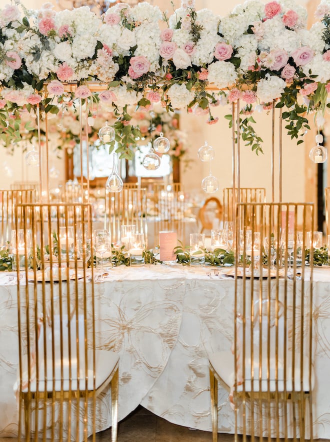 Florals in white and shades of pink hanging above the reception tables.