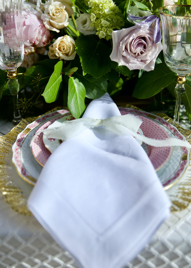 Pink fine china on a golden rimed plate set the table space of the wedding editorial at The Royal Oaks Country Club. 