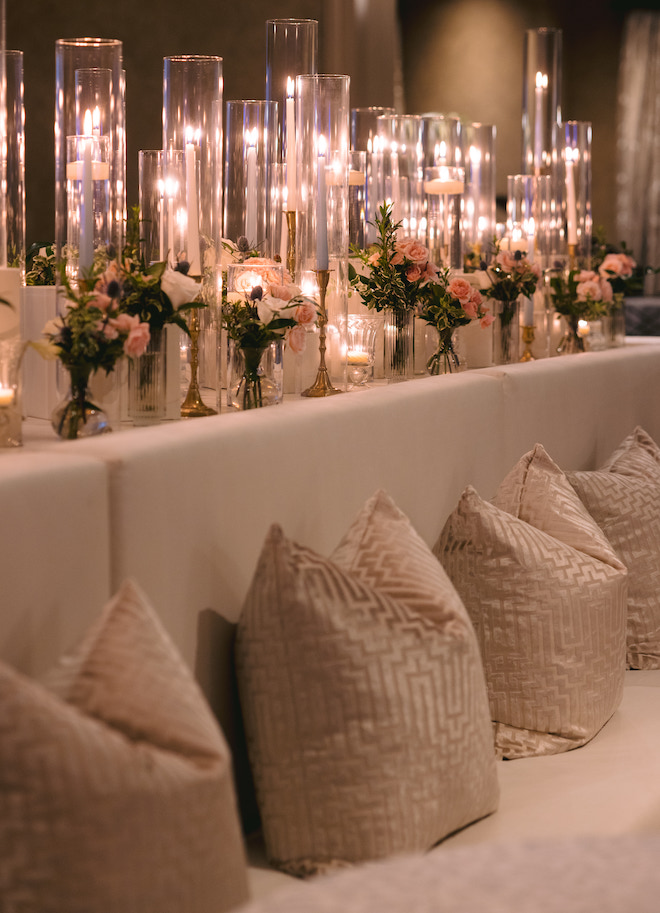 A seating area with pillows decorated with candlelight and florals.