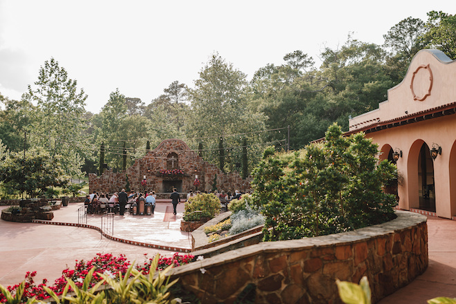 The alfresco ceremony space with guests sitting facing the spanish-style altar. 