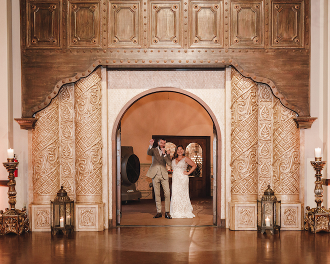 The bride and groom smiling in the entryway of the spanish-inspired reception space.