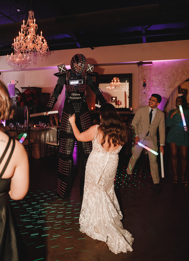 The bride dancing with an LED robot on the dance floor. 