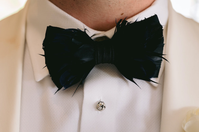 Groom wearing a feathered bow tie at Royal Oaks Country Club. 