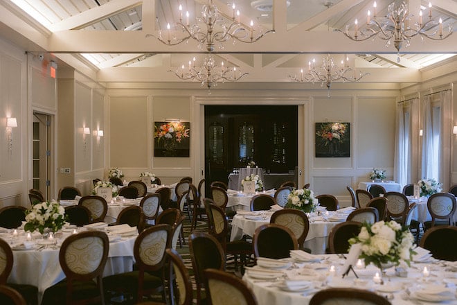 Brennan's of Houston decorated in white tablecloths and white florals for a rehearsal dinner.