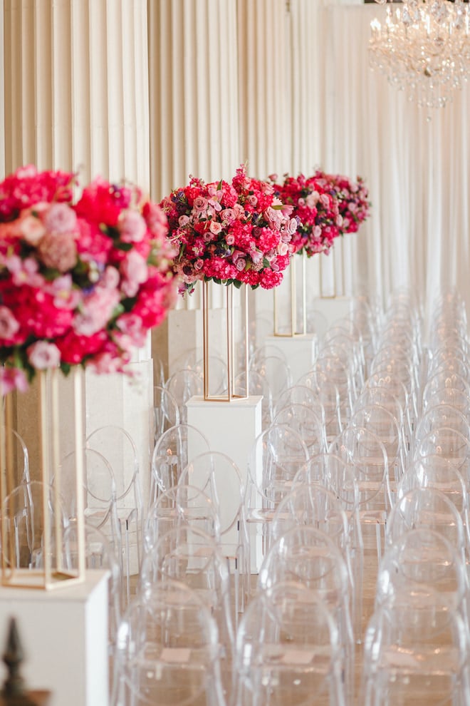 Ghost chairs and rich pink florals for a wedding ceremony at the Corinthian Houston.