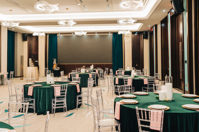 The Blossom Hotel ballroom decorated in emerald green linens with pink napkins for the emerald green weddings editorial.