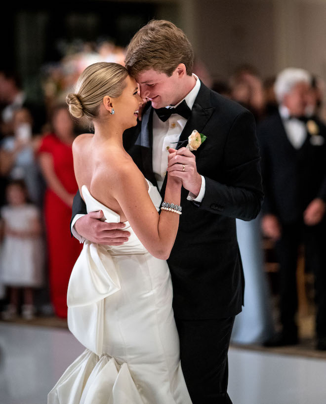 The bride and groom smiling during their first dance.