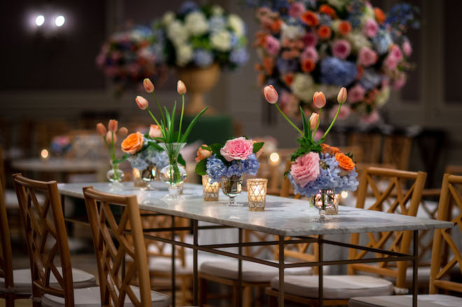 The reception table decorated with pink and blue florals and orange tulips.