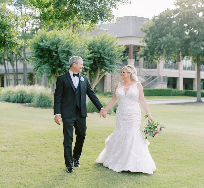 Bride and groom hold hands at the Woodlands Country Club in Houston on their wedding day