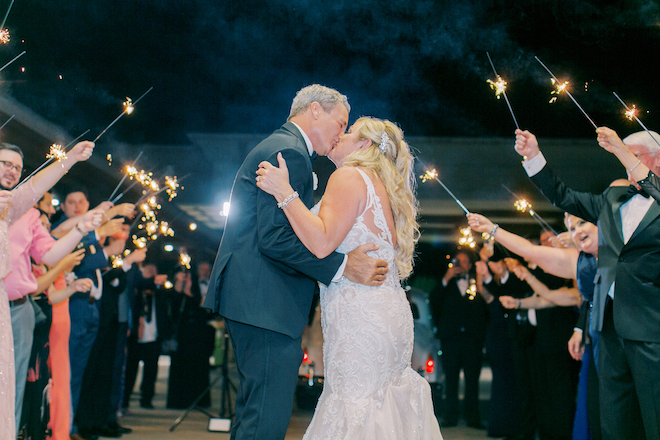 The bride and groom kissing during their sparkler sendoff. 