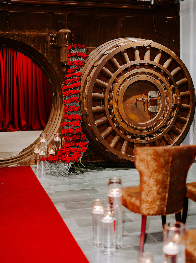 The copper vault at the Corinthian Houston is the setting for the wedding ceremony detailed in red roses and warm candlelight. 
