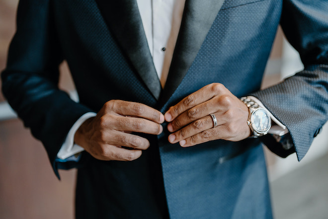 The groom buttons up his navy tuxedo from b.Kreps&co. 