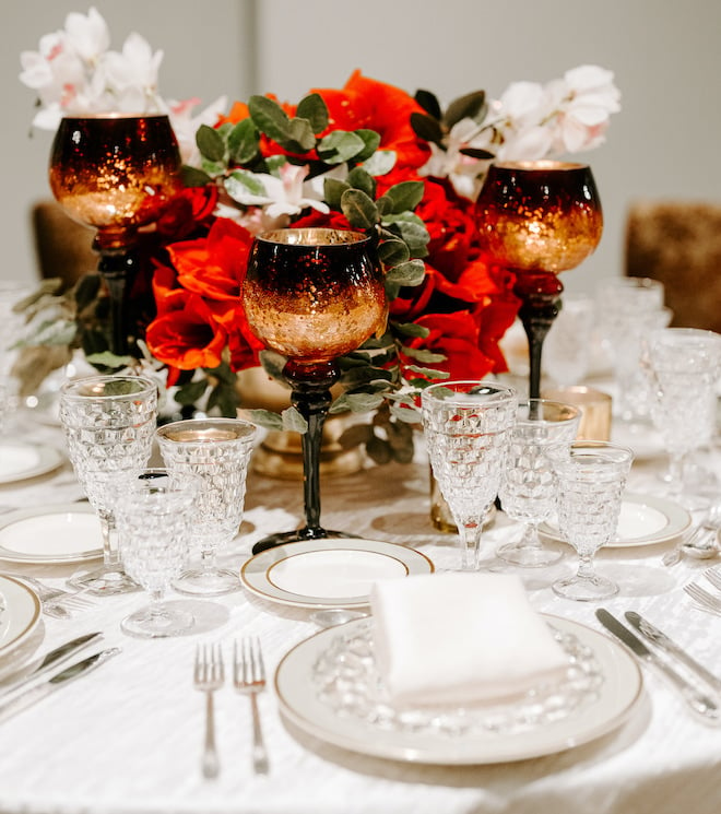 Red flowers and fine china decorate the reception table's at The Vault Corinthian Houston.