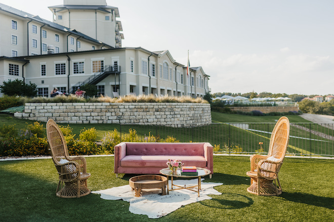 A pink couch and chairs set up on the lawn for a wedding at Omni Barton Creek Resort and Spa.
