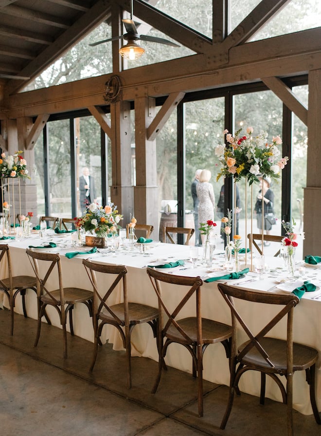 A long reception table in a pavilion used for a wedding reception.