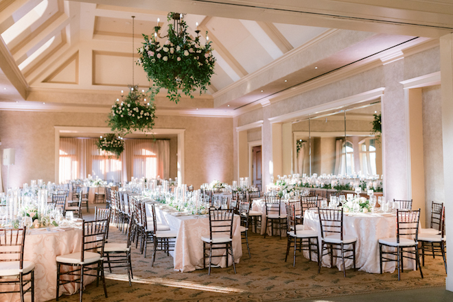 Round banquet tables and a family style table decorated with florals and candles for a wedding reception at royal oaks country club.