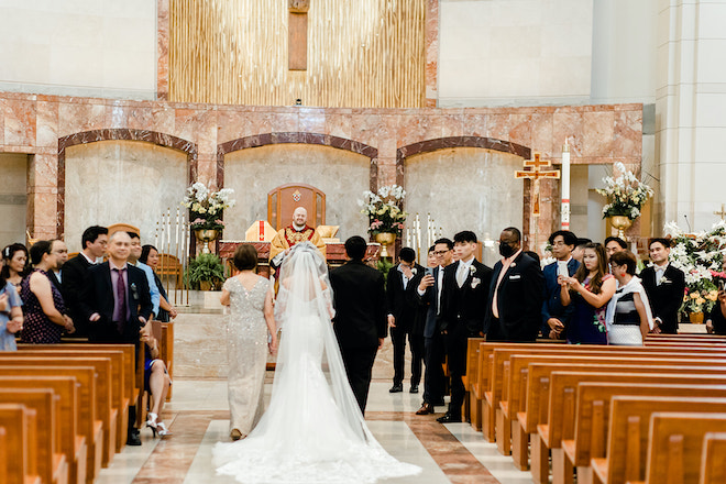 The bride and her parents walking down the aisle.