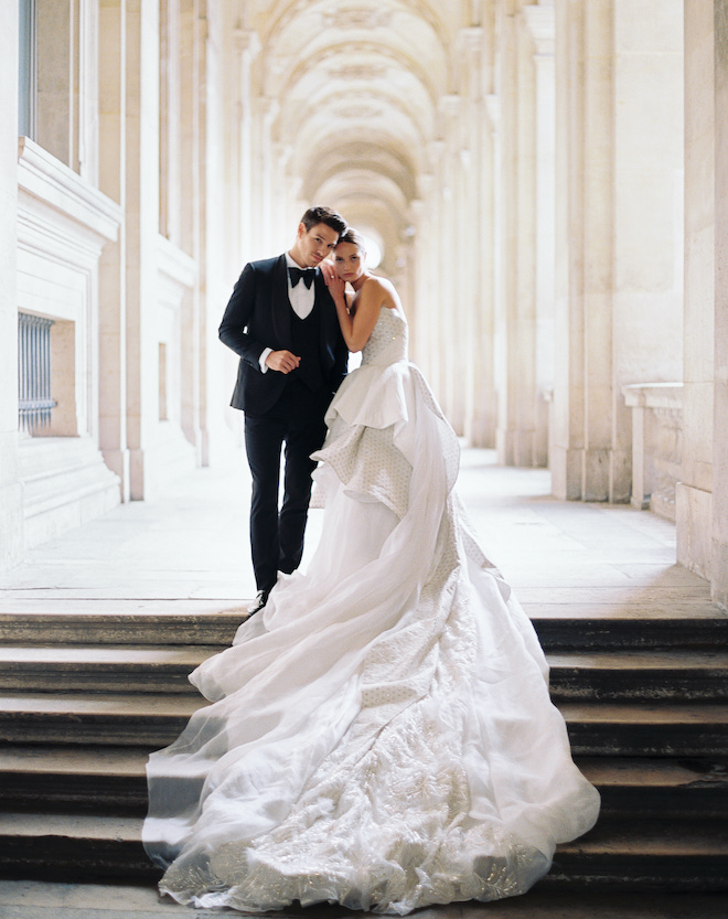 The bride resting her head and hands on the grooms shoulder, for the Parisian love story by Sean Thomas Photography.