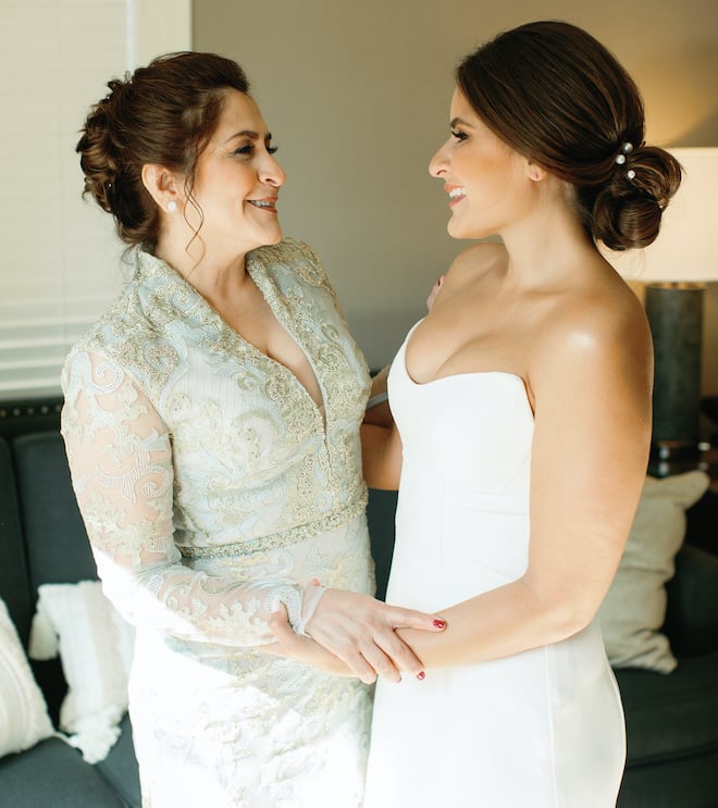 The bride and her mother smiling at each other.