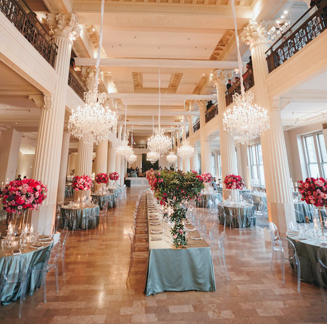 The Corinthian ballroom decorated in green linens and pink floral centerpieces.