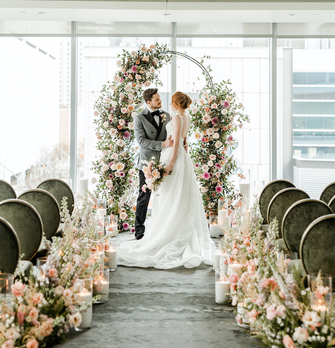 The bride and groom under the floral filled altar at the light & airy wedding editorial.