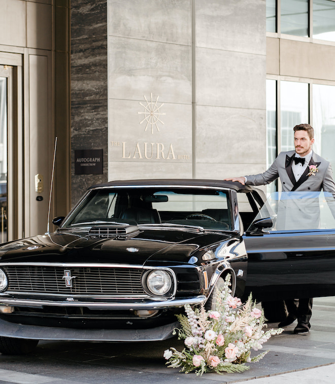 The groom getting into a car in front of The Laura Hotel.