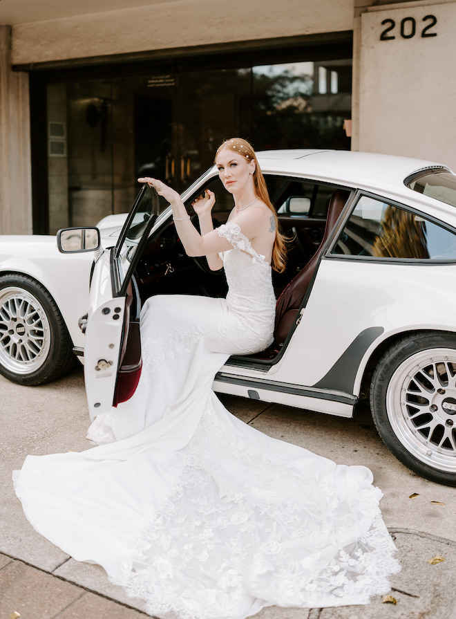 The bride sitting in a 1987 Porsche 911 with her timeless soft glam bridal look.