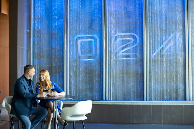 A couple enjoying glasses of wine in front of 024 Grille.