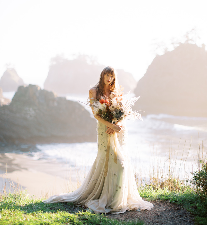 The bride holding a bouquet of flowers on the Oregon Coast.