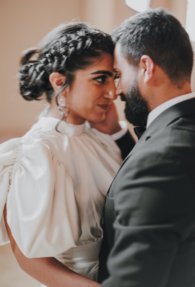 The couple pressing their foreheads together and smiling at their engagements at The Bell Tower on 34th.