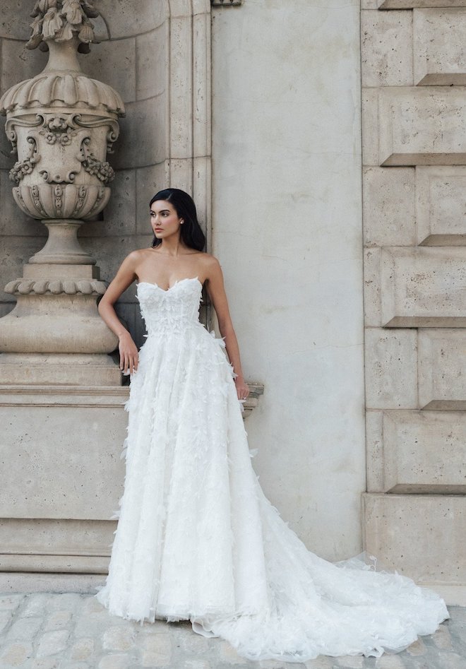 A strapless scoop neck gown with feathery appliques in the Spring 2024 Collection by Anne Barge.