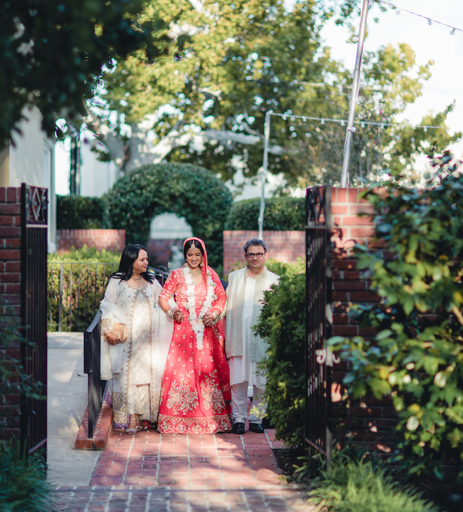 The bride and her parents walking down the aisle.