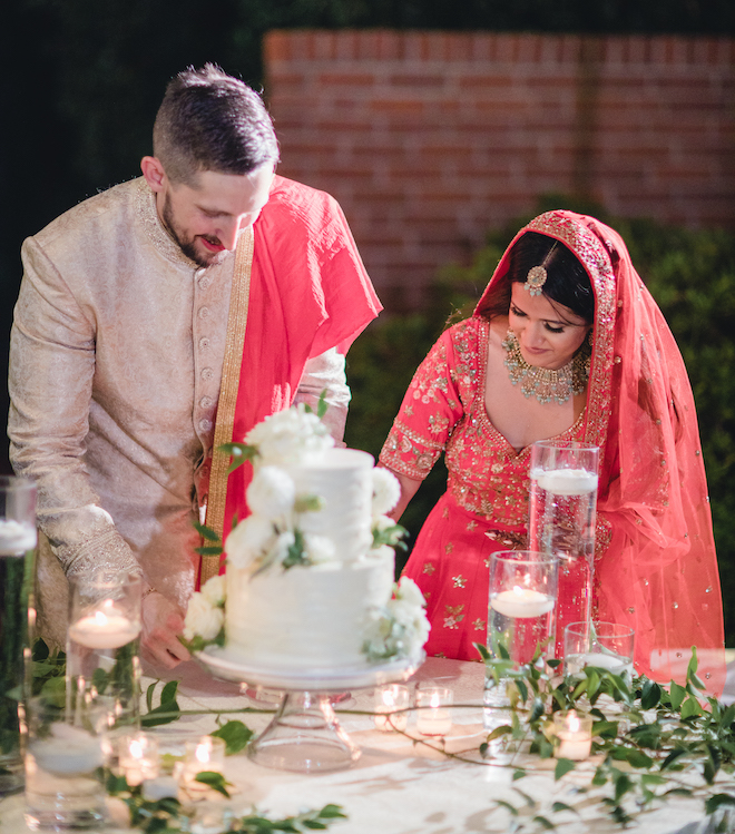 The bride and groom cutting a piece of cake.