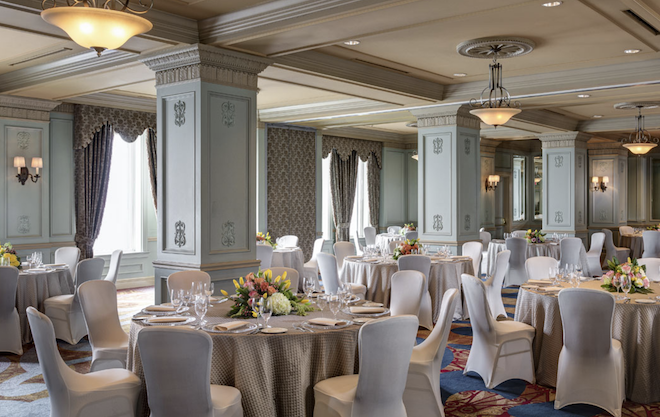 The ballroom in Hotel Icon with grand ceilings and windows.