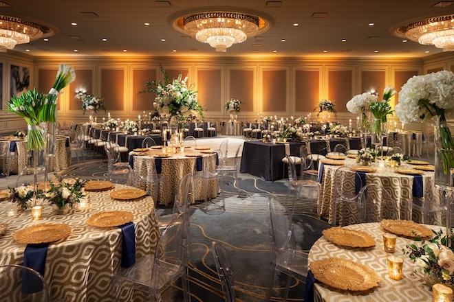 The Westin Galleria ballroom decorated with floral centerpieces and brown and blue decor.