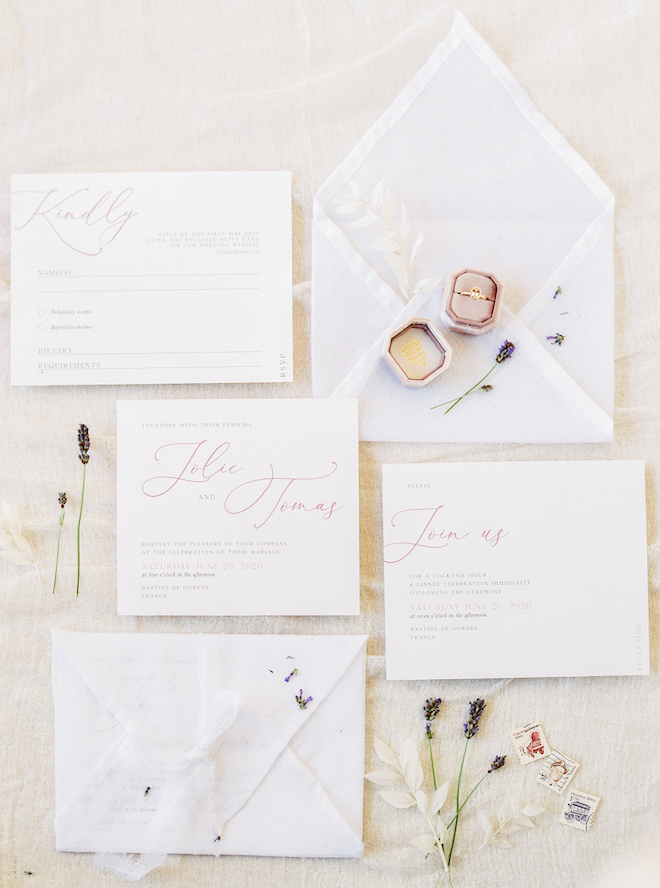 A simple white invitation suite with pink font and florals.